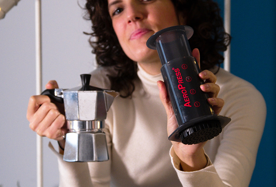 Woman holding AeroPress Original and moka pot