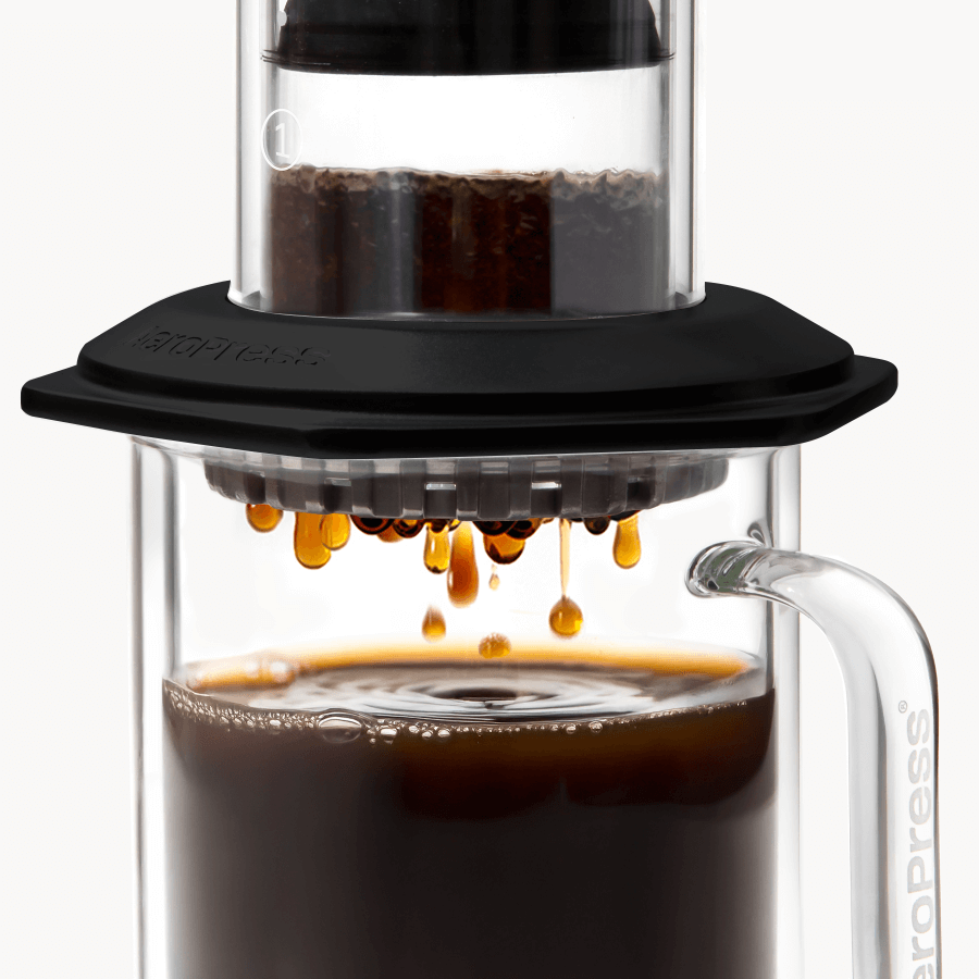 AeroPress Premium coffee maker with coffee being poured into a glass container.