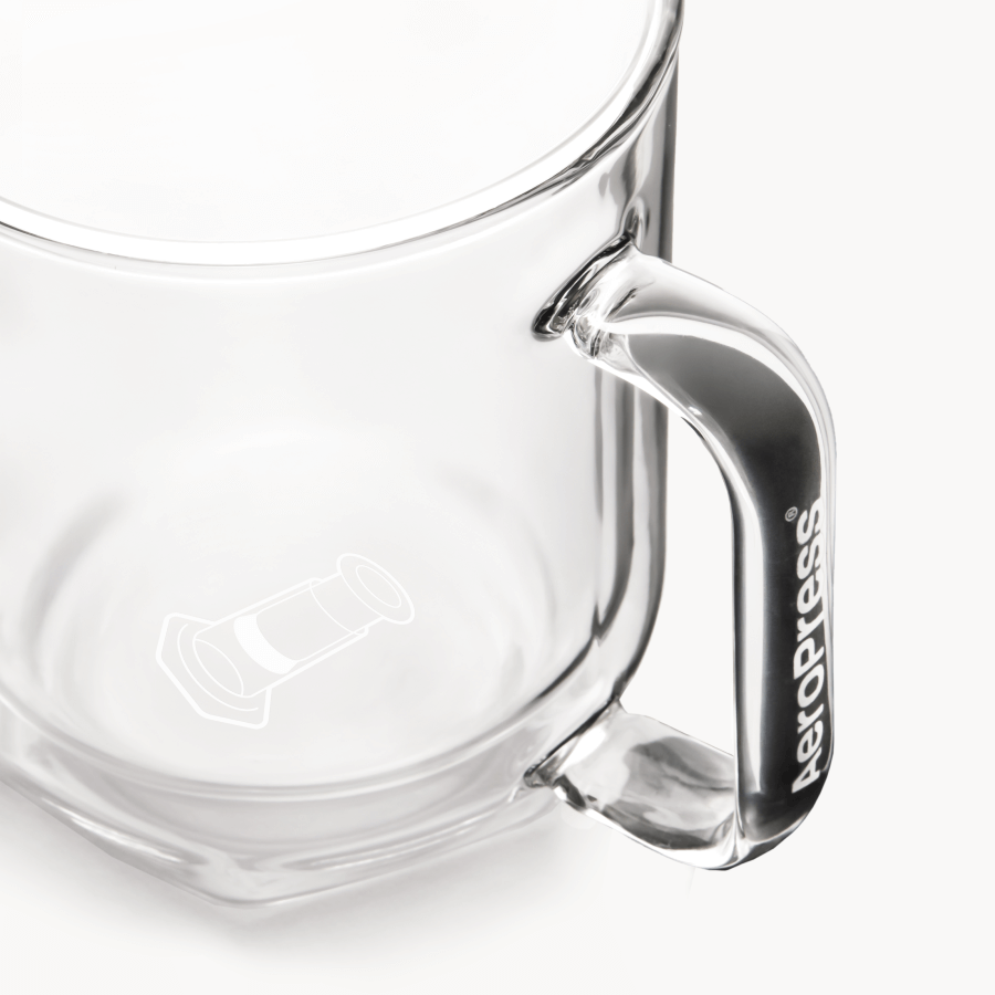 Clear glass AeroPress Mug with handle on a white background
