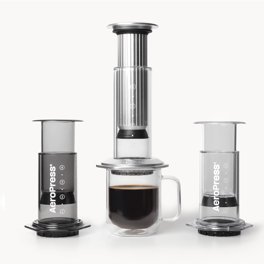 AeroPress coffee maker lineup with a cup of coffee on a white background