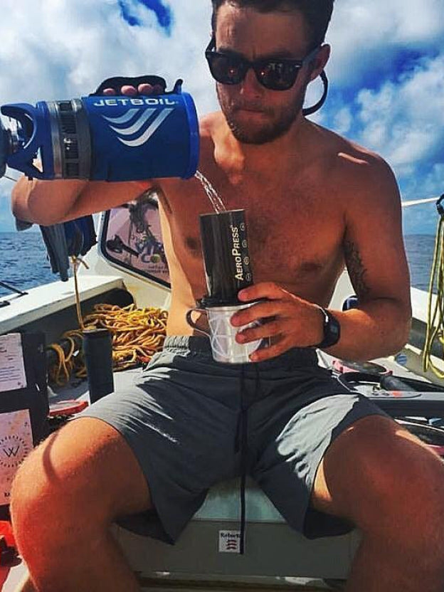 Man pouring water into AeroPress Original on boat