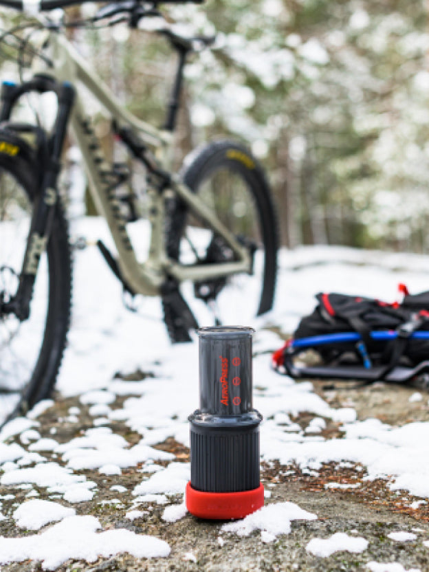 AeroPress Go next to bicycle on snowy trail