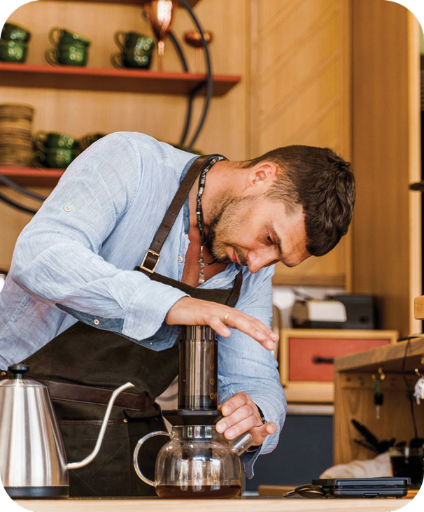 Barista with apron pressing AeroPress
