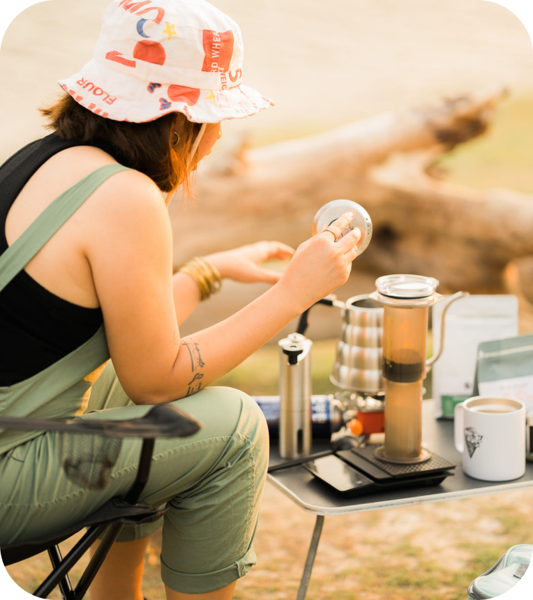 Woman brewing outside with AeroPress Original