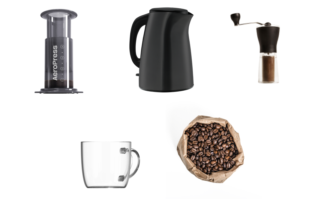 AeroPress Original next to kettle, hand grinder, glass mug and coffee beans