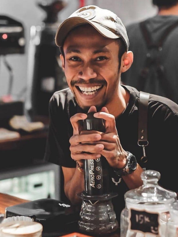 Smiling barista brewing with AeroPress Original