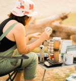 Woman brewing outside with AeroPress Original
