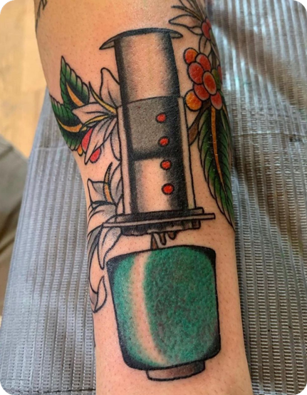 AeroPress tattoo with green cup and flowers