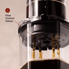 Close-up of AeroPress coffee maker with flow control valves highlighted.