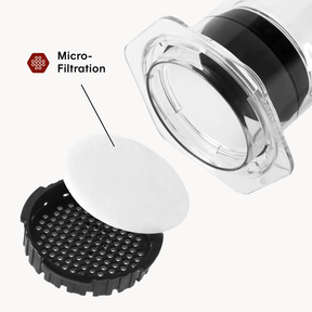 Up close shot of AeroPress filter cap and white paper filter on white background