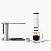 AeroPress Premium coffee maker with a glass of coffee on a white background

#color_white
