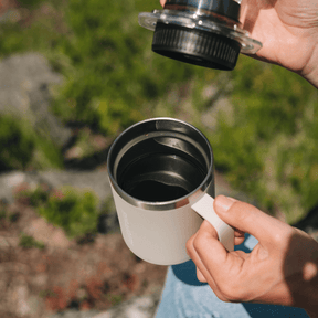 Person holding an AeroPress Stainless Steel Travel Coffee Mug over a natural background