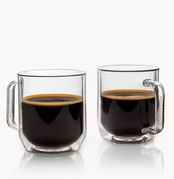 Two clear glass mugs filled with black coffee on a white background