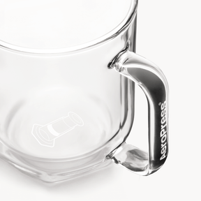 Clear glass AeroPress Mug with handle on a white background