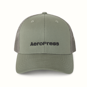 Green cap with 'AeroPress' logo on a white background 