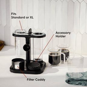 Black coffee accessory holder with labeled parts on a kitchen counter.