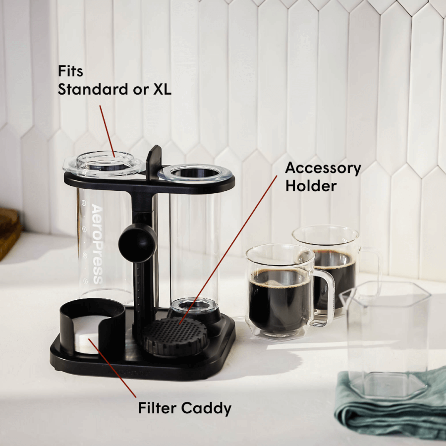 Black coffee accessory holder with labeled parts on a kitchen counter.