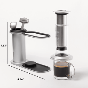 Aeropress coffee maker with a glass mug of coffee on a white background