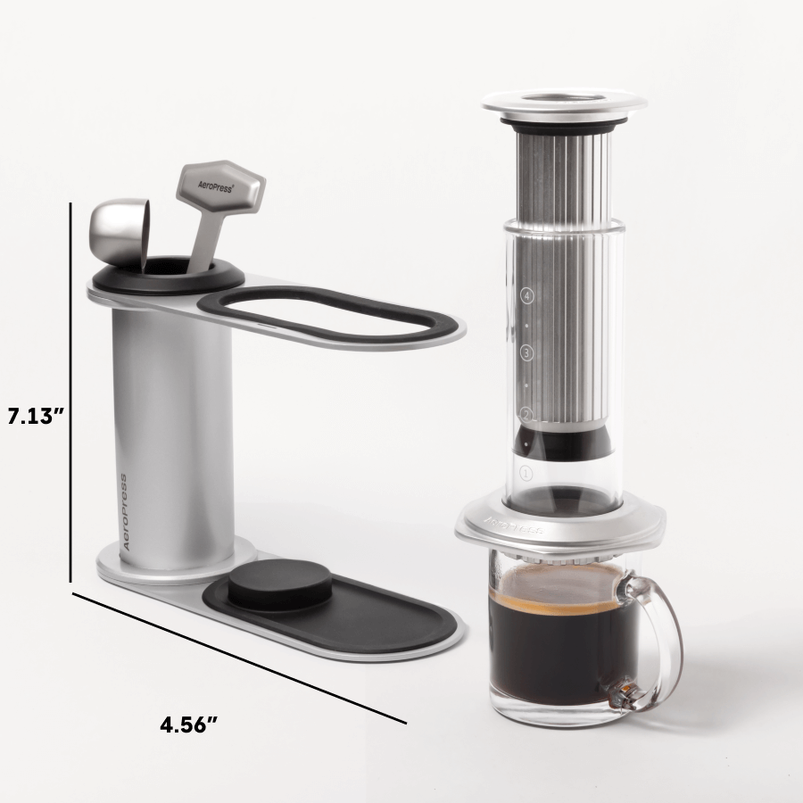 Aeropress coffee maker with a glass mug of coffee on a white background