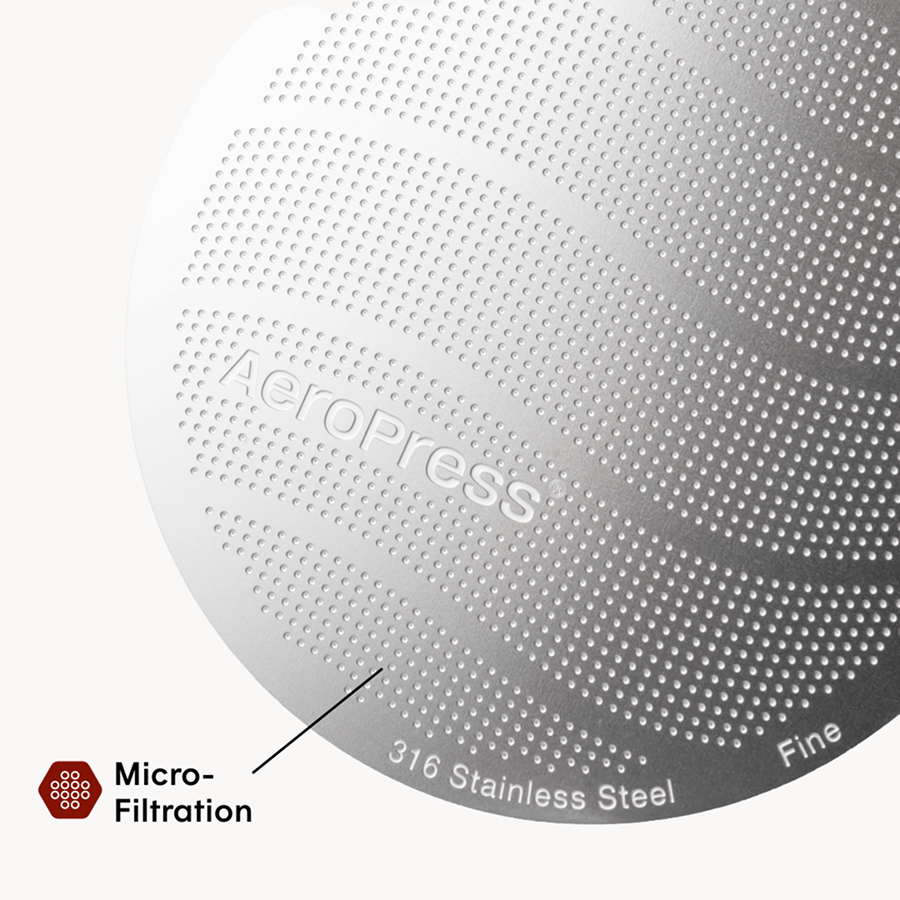 Close-up of a metallic surface with 'Aeropress' branding and text indicating micro-filtration and stainless steel material.