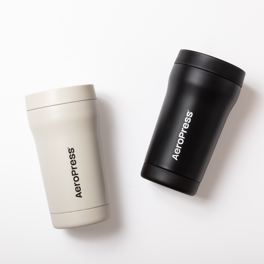 Two AeroPress tumblers, one cream and one black, on a white background #color_black