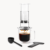 Coffee brewing device with a glass mug and scoop on a white background #color_clear