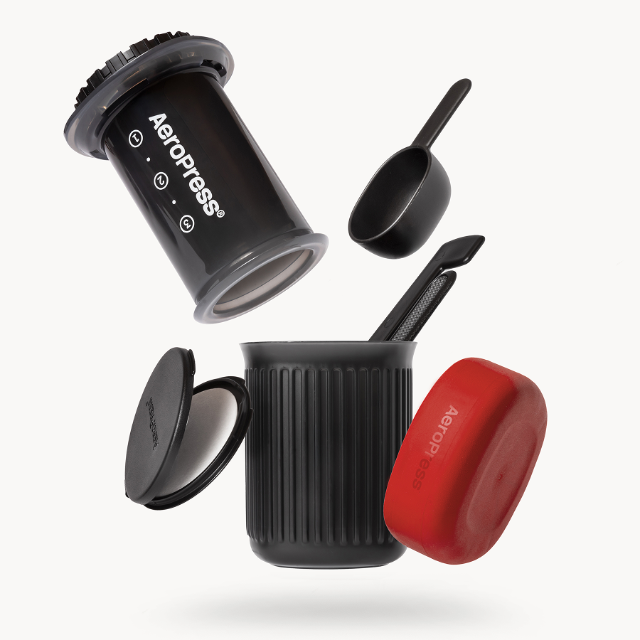AeroPress Go coffee maker with red lid and black scoop on a white background