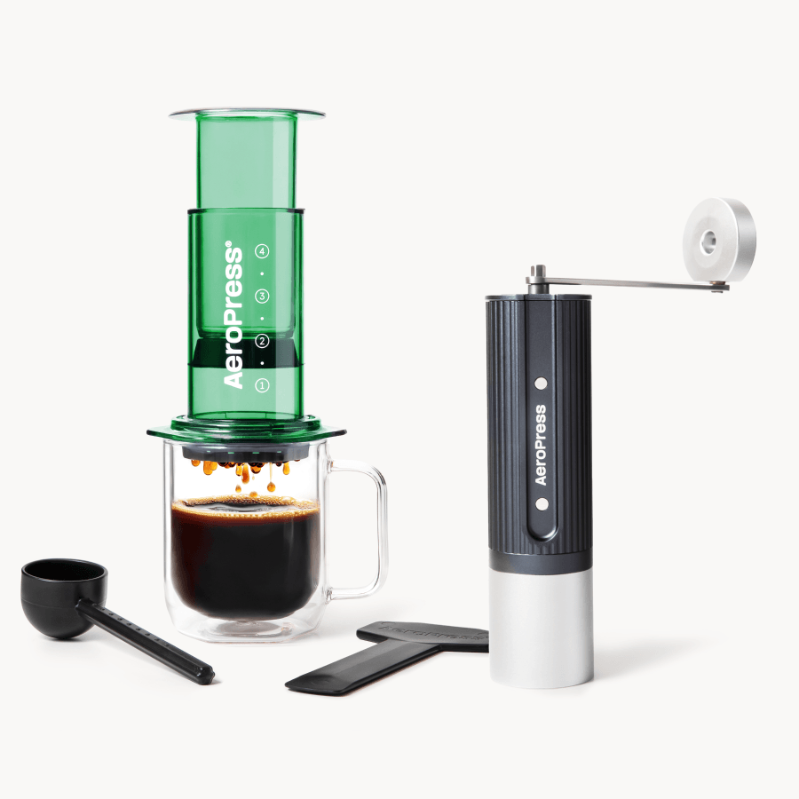 Aeropress coffee maker with a green chamber, black handle, and white base on a white background. #color_Green