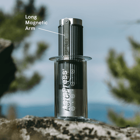 AeroPress coffee maker with grinder highlighted against a natural background #color_Green