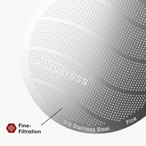 Close-up of a metallic AeroPress XL coffee maker with '316 Stainless Steel' text on a white background.