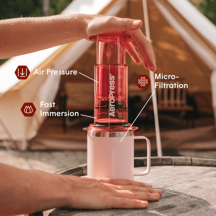 Aeropress coffee maker being used with a tent in the background #color_Pink