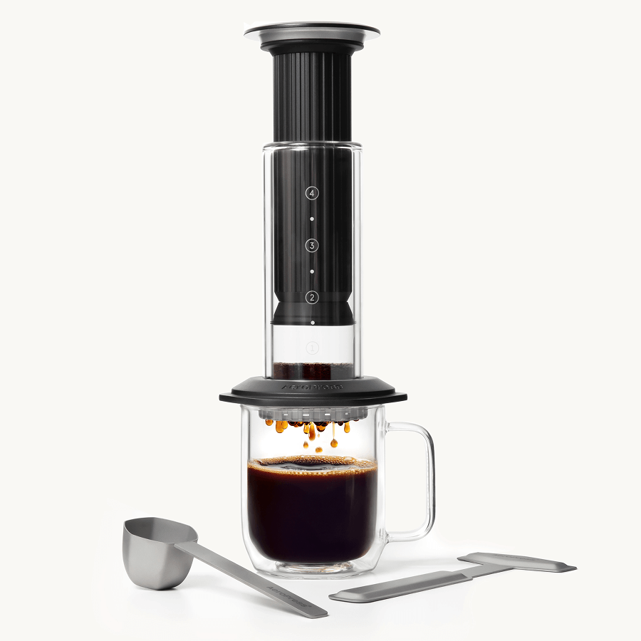 Black AeroPress Premium coffee maker with glass mug on a white background #color_black