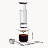 AeroPress Premium coffee maker with glass mug and scoop on a white background #color_white
