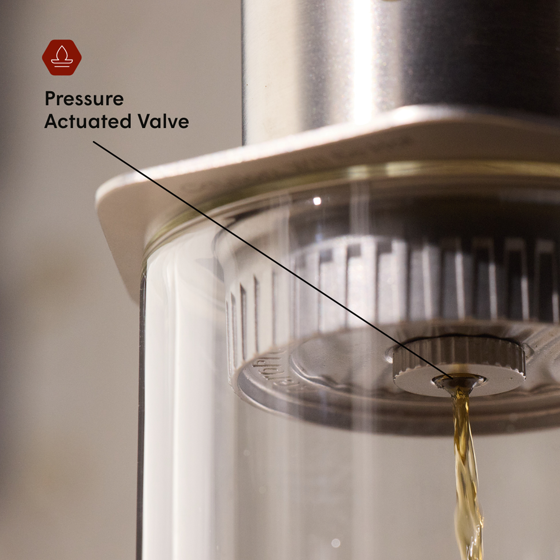 Close-up of a pressure actuated valve in a coffee brewing device with a blurred background. #color_silver
