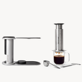Aeropress coffee maker with a glass of coffee on a white background #color_silver