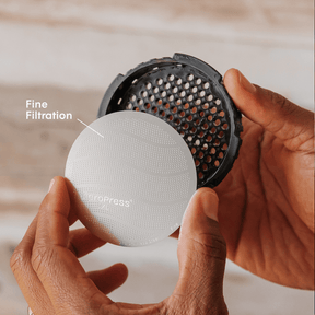 Hand holding a coffee filter with 'Espro' branding and 'Fine Filtration' text.