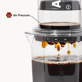 Coffee brewing apparatus with air pressure indicated, showing coffee dripping.