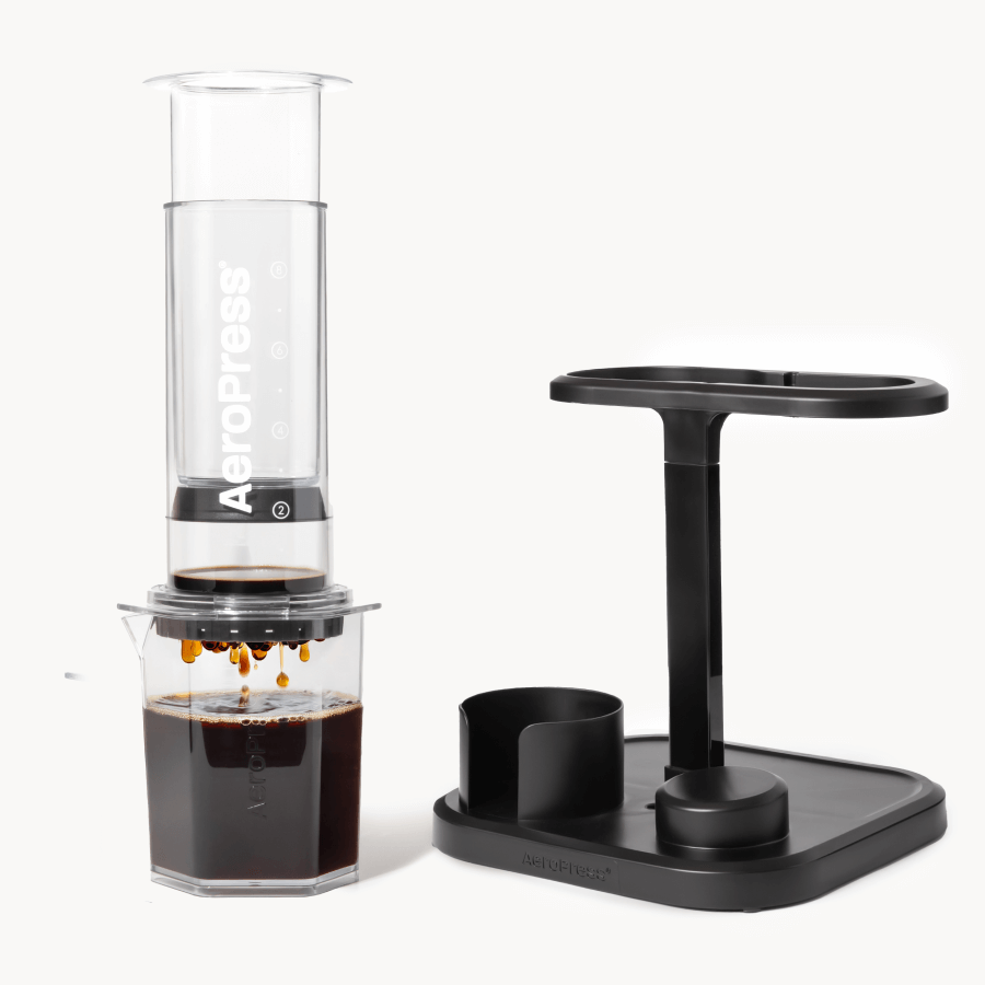 AeroPress coffee maker with a black stand on a white background