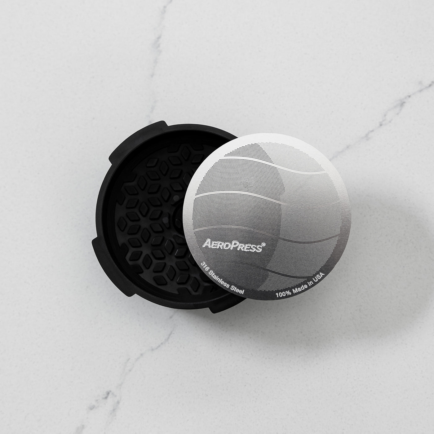 AeroPress Flow Control Filter Cap with metal filter on marble counter