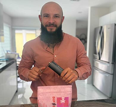 Man holding a manual coffee grinder in a kitchen