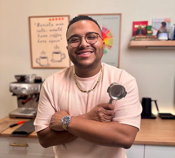 Man holding a coffee scoop in a kitchen setting
