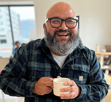 Eduardo Choza holding a mug of coffee indoors