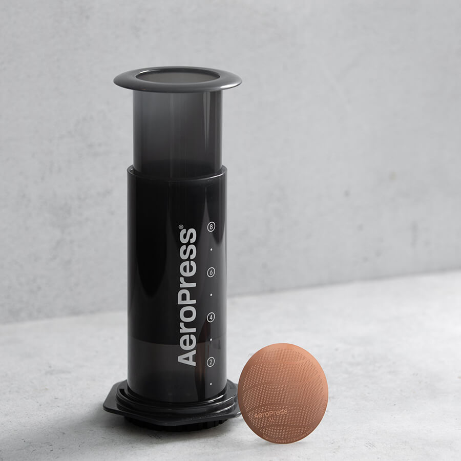 Gold Tone Filter XL leaning against AeroPress XL