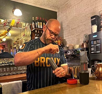 Barista preparing a drink behind the counter in a coffee shop.