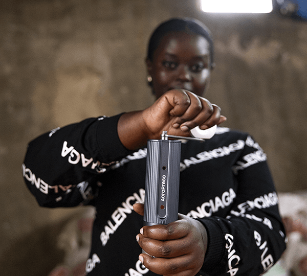 Person holding a manual grinder with a blurred background