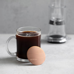 Gold Tone Filter leaning against cup of coffee