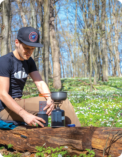 AeroPress Go next to camping stove in forest