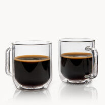 Two glass mugs filled with black coffee on a white background
